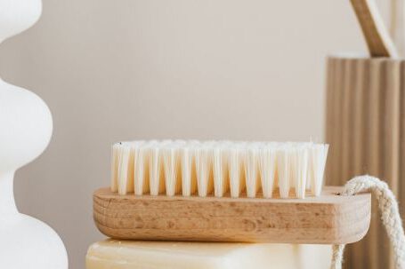 Sustainable Decor - Sustainable consumption concept collection of organic cruelty free soaps with wooden body brush near bamboo sustainable toothbrushes and ceramic white vase on marble tabletop in minimalist bathroom