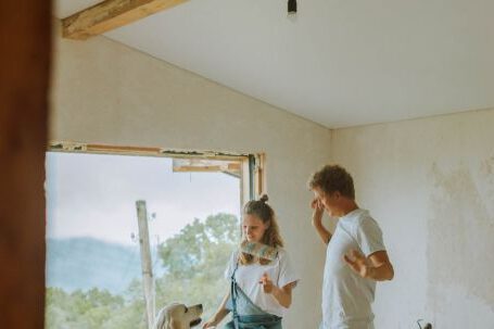 Renovation Tips - A Happy Couple Dancing With Their Dog
