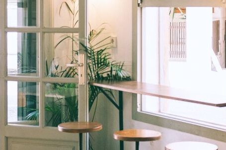 Furniture - Interior of stylish cafe with wooden counter and stools placed near window