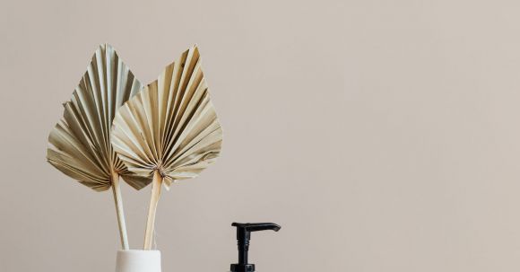 Storage Hacks - Set of cosmetic supplies near decorative leaves in vase on marble shelf