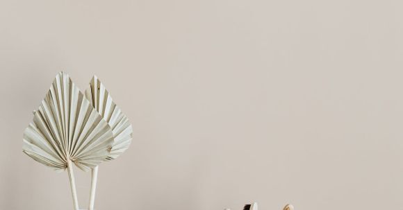 Sustainable Decor - White creative vase with decorative artificial plants and organic soap with body brush placed near set of bamboo toothbrushes in ceramic holder and dark glass reusable bottle of lotion
