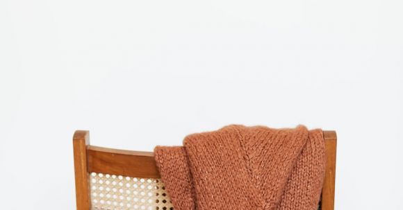 Storage Hacks - Brown coarse wool sweater hung on back of woooden chair against white wall