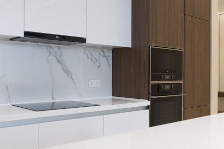 Kitchen Renovation - White and wooden furniture in modern kitchen with contemporary appliances