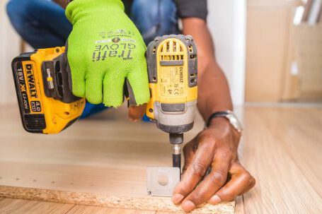 Renovation Tips - Person Using Dewalt Cordless Impact Driver on Brown Board