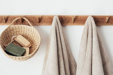 Sustainable Decor - Wooden hanger with towels and basket with bathroom products